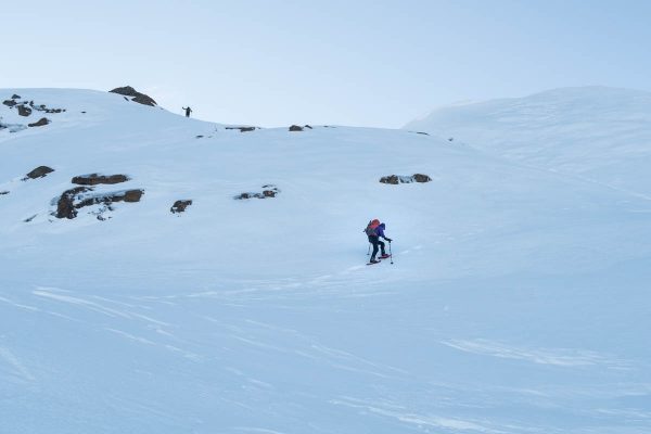two figures hiking up snow covered slopes on Adder Mountain