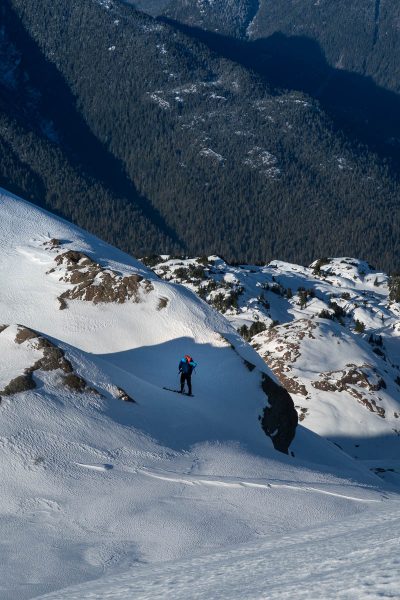 a man stands on the edge of a steep slope on Adder Mountain
